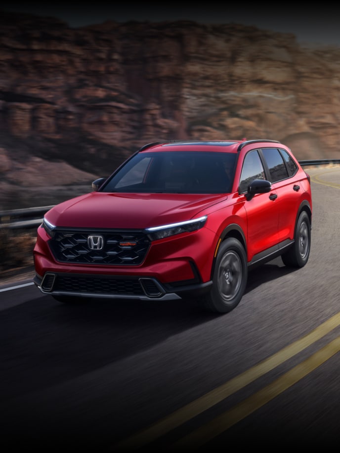 2026 Honda CR-V TraiSport in Radiant Red Metallic, 3/4 driver front of vehicle driving on a curvy canyon road