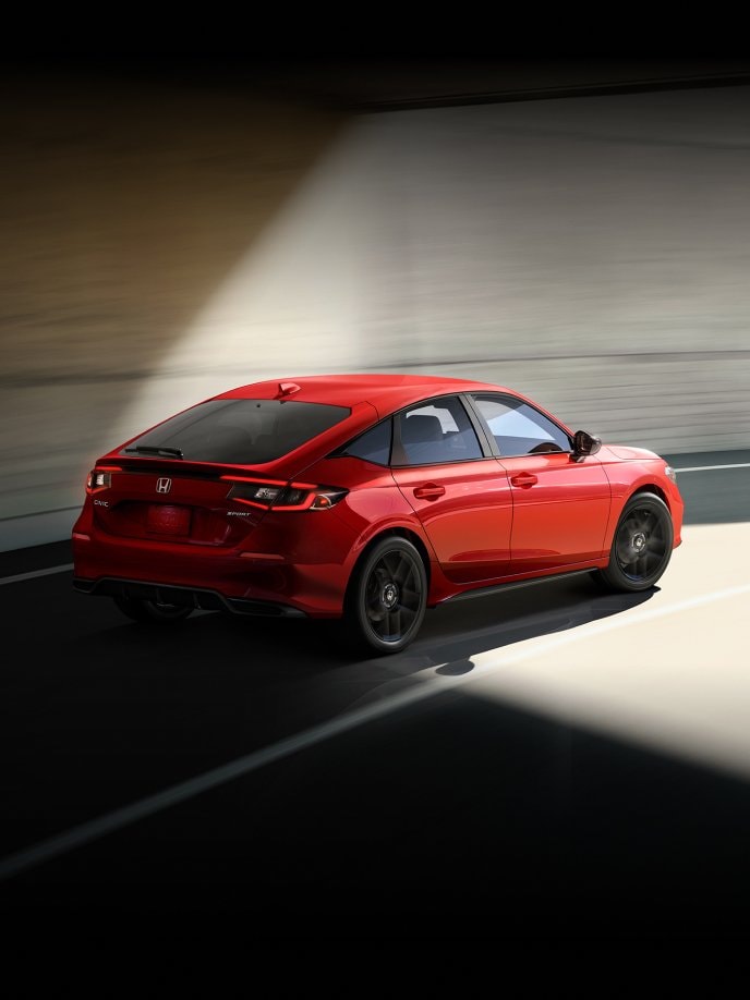 2025 Honda Civic Hatchback Sport in Rallye Red coming out of a tunnel