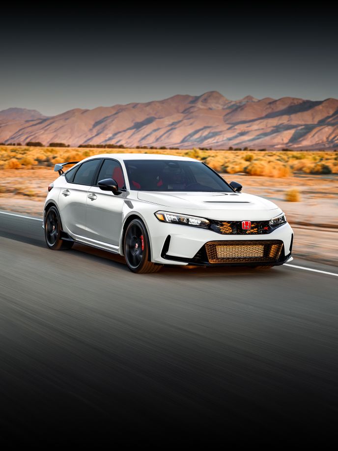 2025 Honda Civic Type R in Championship White front view driving in a road with desert background