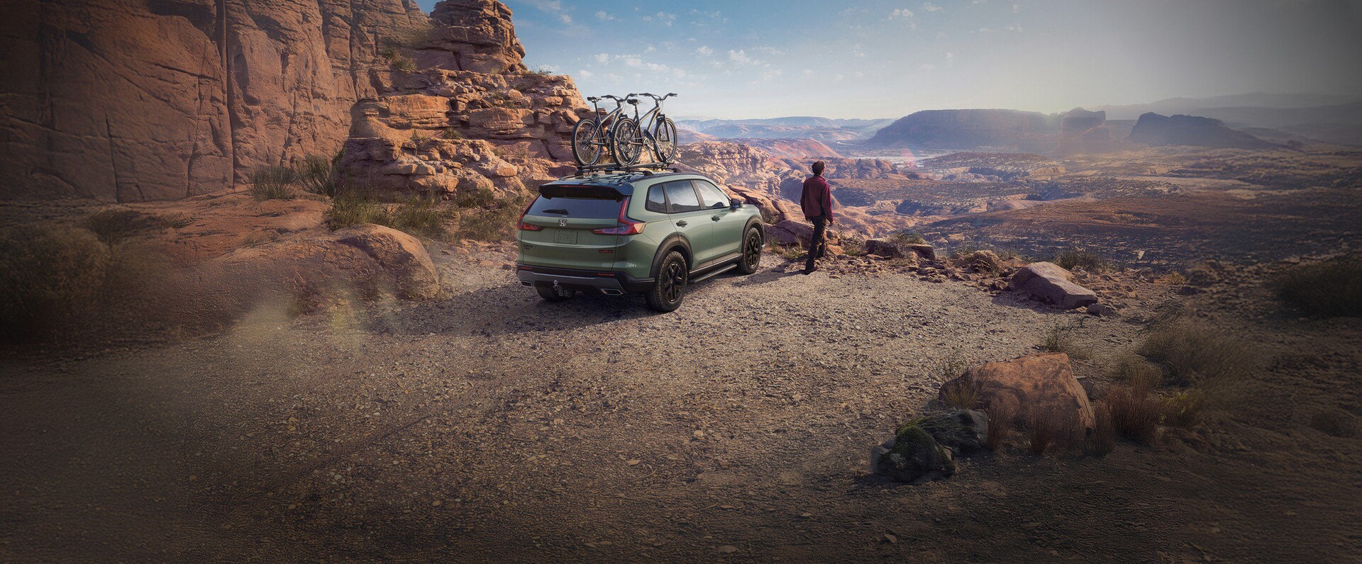 2026 Honda CR-V TrailSport in Ash Green Metallic, 3/4 passenger front of vehicle driving on a dirt road through desert national park landscape
